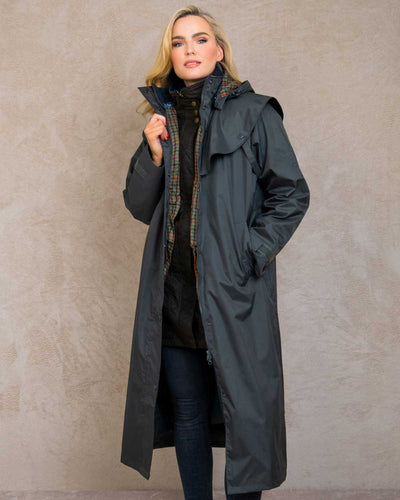 Olive coloured Jack Murphy Malvern Ladies Waterproof Bush Coat on wall background #colour_olive