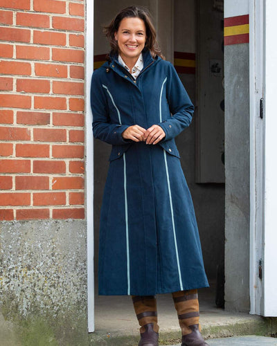 Navy Blue Coloured Baleno Kensington Safe Womens Long Riding Coat On A wall Background #colour_navy-blue