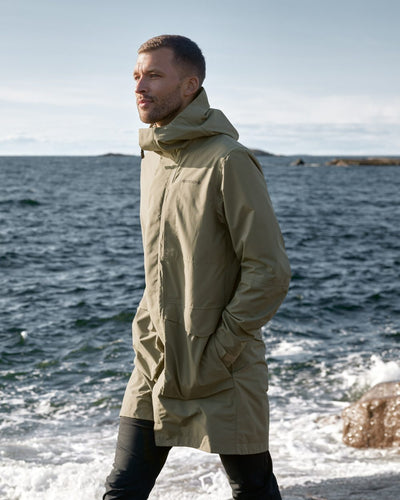 Deep-green Coloured Didriksons Andreas Unisex Parka 2 On A Coastal Background #colour_deep-green