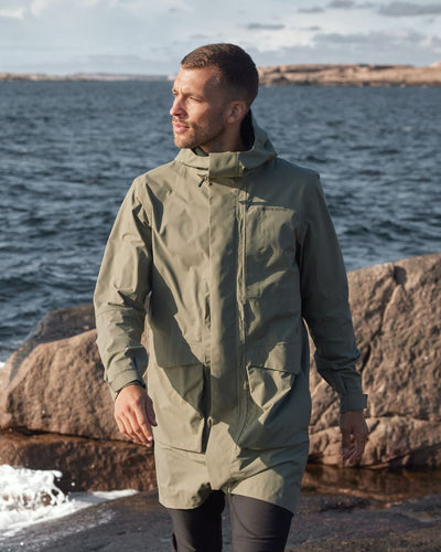 Deep-green Coloured Didriksons Andreas Unisex Parka 2 On A Coastal Background #colour_deep-green