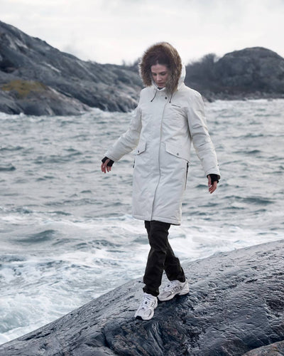 White Foam Coloured Didriksons Erika Ladies Padded Waterproof Parka 3 On A Coastal Background #colour_white-foam