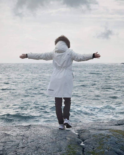 White Foam Coloured Didriksons Erika Ladies Padded Waterproof Parka 3 On A Coastal Background #colour_white-foam