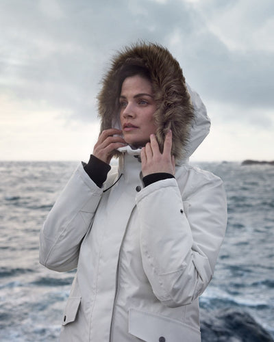 White Foam Coloured Didriksons Erika Ladies Padded Waterproof Parka 3 On A Coastal Background #colour_white-foam