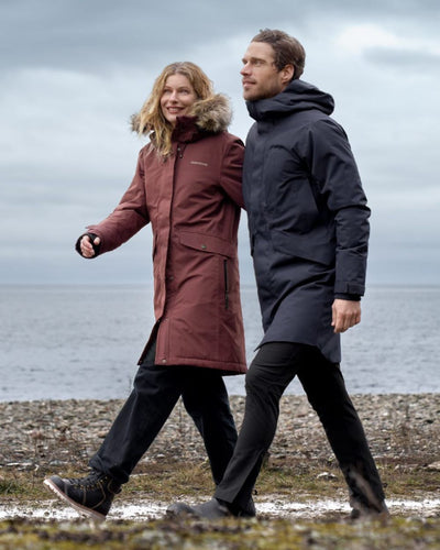 Old Rust Coloured Didriksons Erika Ladies Padded Waterproof Parka 3 On A Coastal Background #colour_old-rust