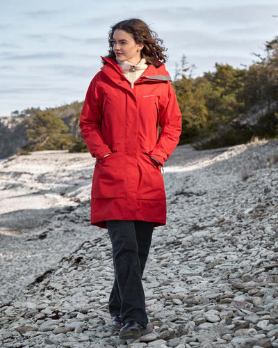 Pomme Red coloured Didriksons Womens Parka on beach background #colour_pomme-red