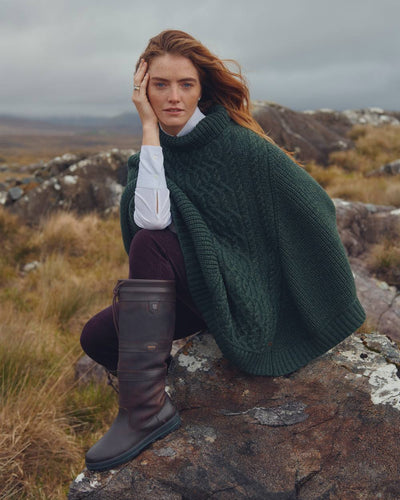 Olive Coloured Dubarry Womens Kilronan Merino Poncho On A Hill Background #colour_olive