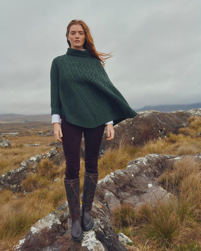 Olive Coloured Dubarry Womens Kilronan Merino Poncho On A Hill Background #colour_olive