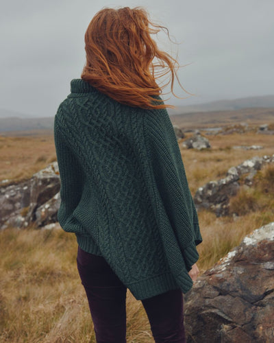 Olive Coloured Dubarry Womens Kilronan Merino Poncho On A Hill Background #colour_olive