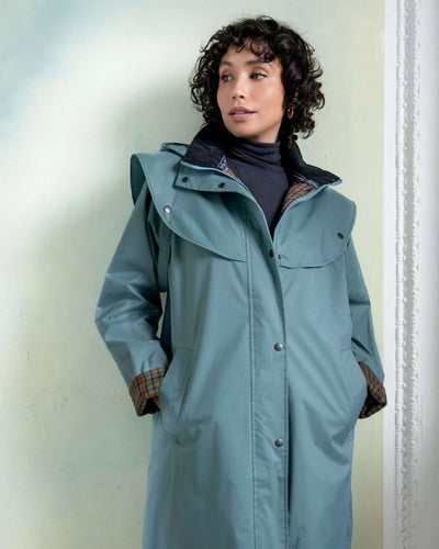 Smoke Blue coloured Jack Murphy Cotswold Ladies Waterproof 3/4 Coat on wall background #colour_smoke-blue