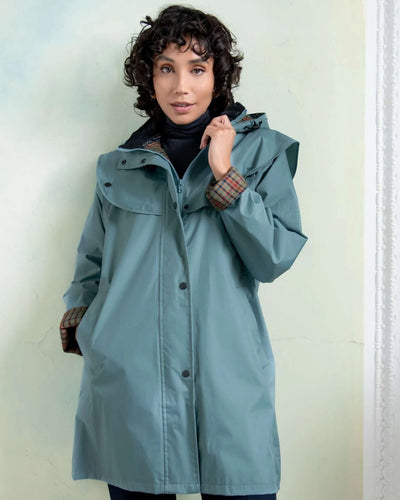 Smoke Blue coloured Jack Murphy Cotswold Ladies Waterproof 3/4 Coat on wall background #colour_smoke-blue