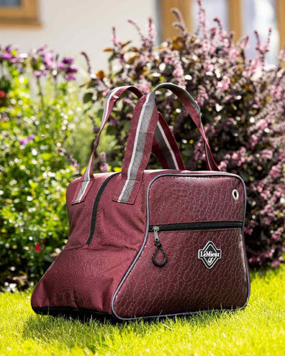 Burgundy coloured LeMieux Elite Pro Short Boot Bag with plant in background #colour_burgundy